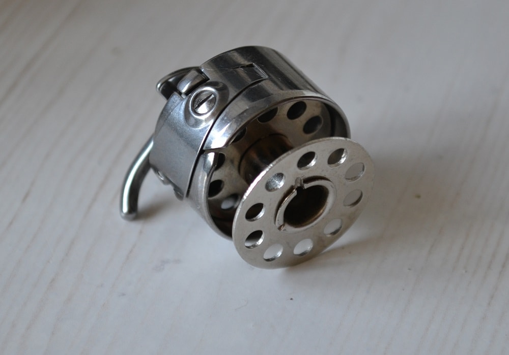 Release the latch and bobbin will fall easily