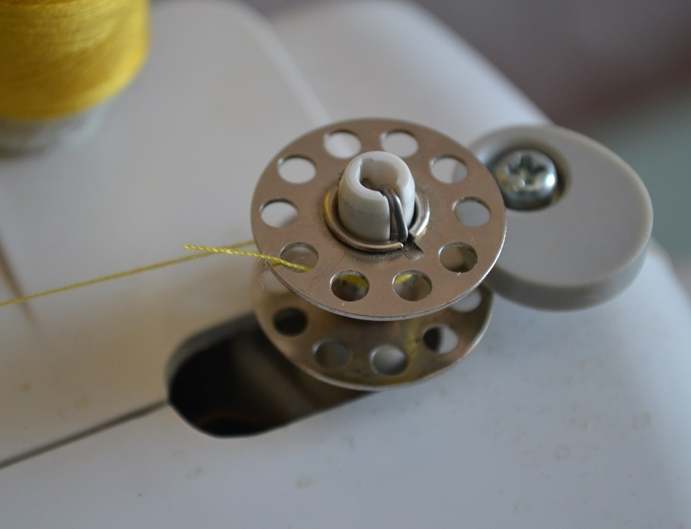 Trim thread end from top of bobbin