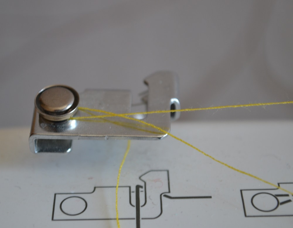 Pass thread from spool through left thread guide