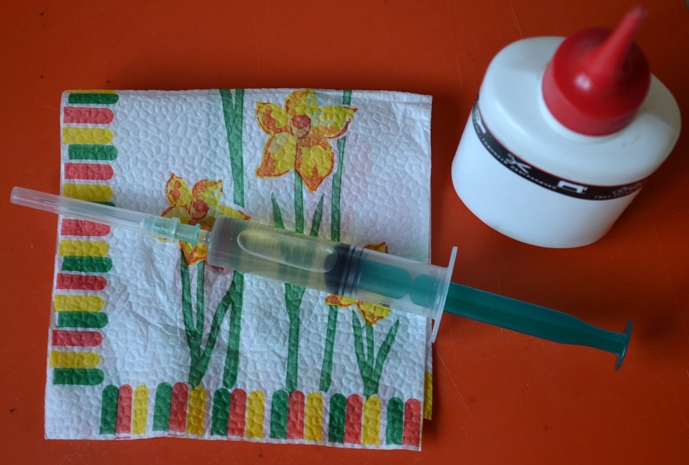 Fill the syringe halfway