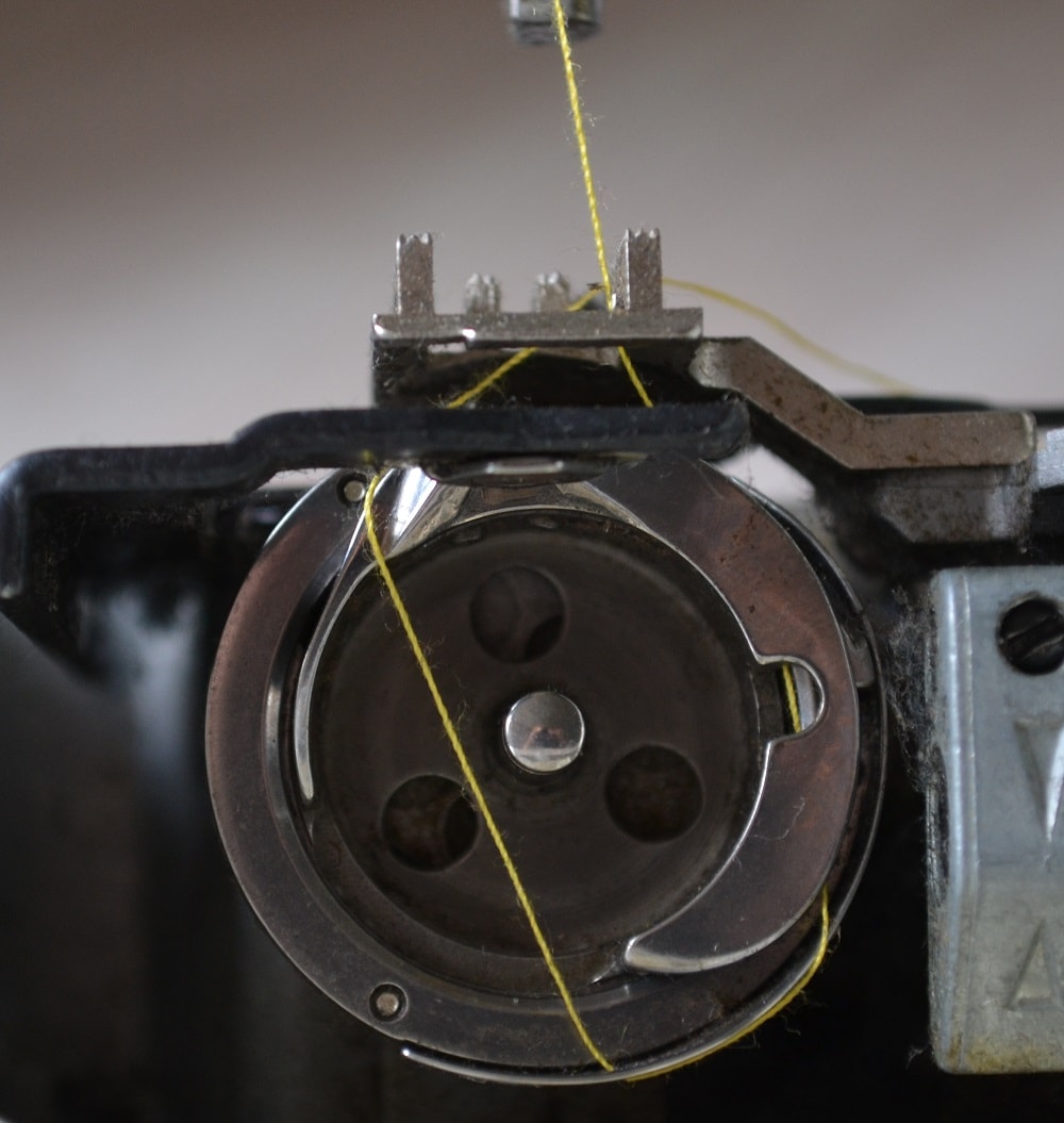 Top thread slips off from shuttle hook surface