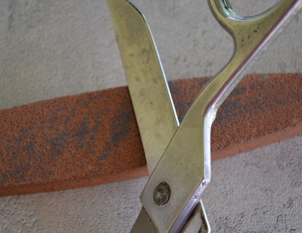 How to hold the scissors in relation to a stone